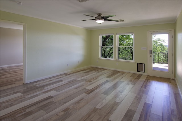 empty room with a wealth of natural light, crown molding, light hardwood / wood-style flooring, and ceiling fan