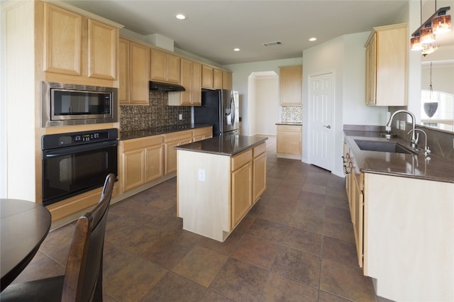 kitchen featuring light brown cabinetry, black appliances, sink, pendant lighting, and a center island