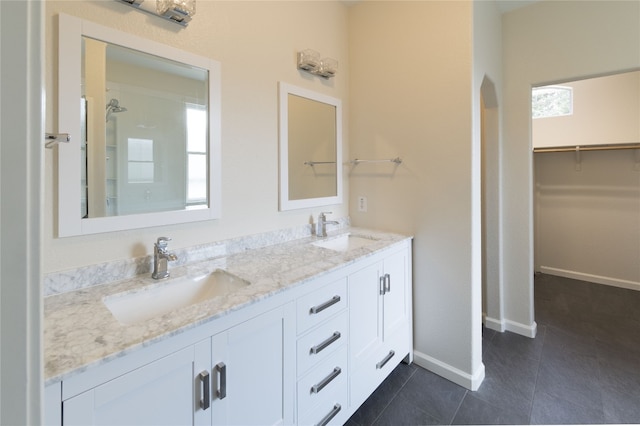 bathroom with vanity, a shower, a wealth of natural light, and tile patterned flooring