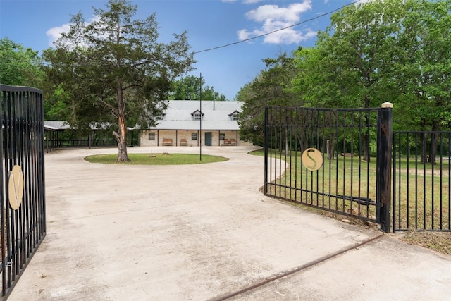 view of gate with a lawn