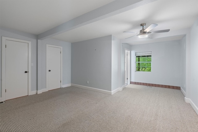 carpeted spare room featuring ceiling fan