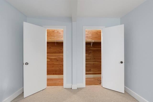 unfurnished bedroom featuring a closet, a spacious closet, and light wood-type flooring