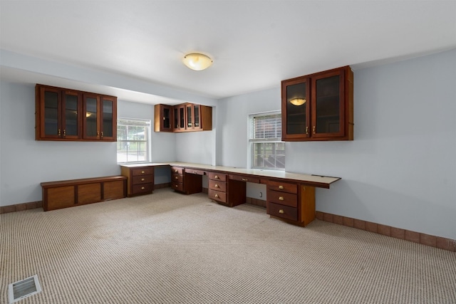 kitchen with light colored carpet and built in desk