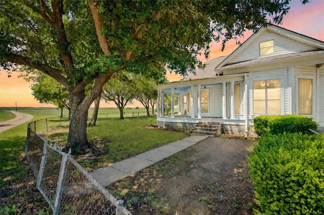 view of front of house featuring covered porch and a lawn