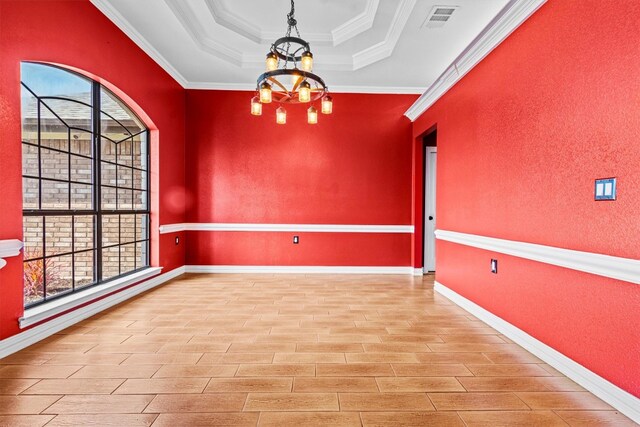 unfurnished room featuring ornamental molding, a notable chandelier, a raised ceiling, and a wealth of natural light