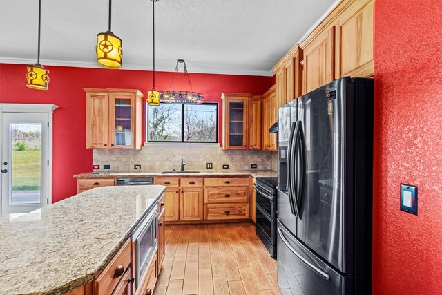 kitchen featuring sink, backsplash, light wood-type flooring, stainless steel appliances, and pendant lighting