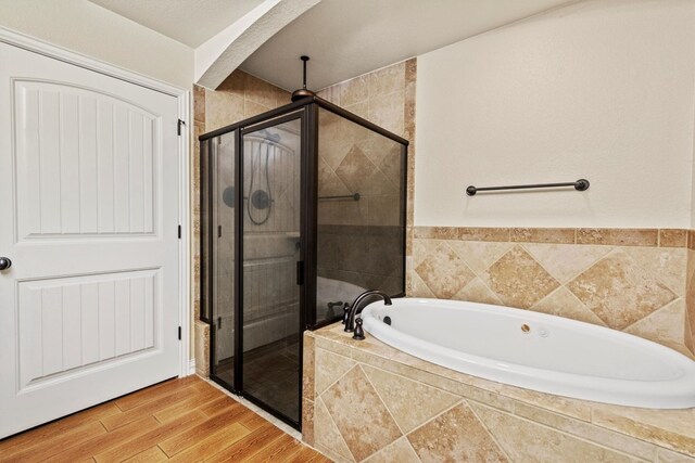 bathroom featuring hardwood / wood-style flooring and shower with separate bathtub