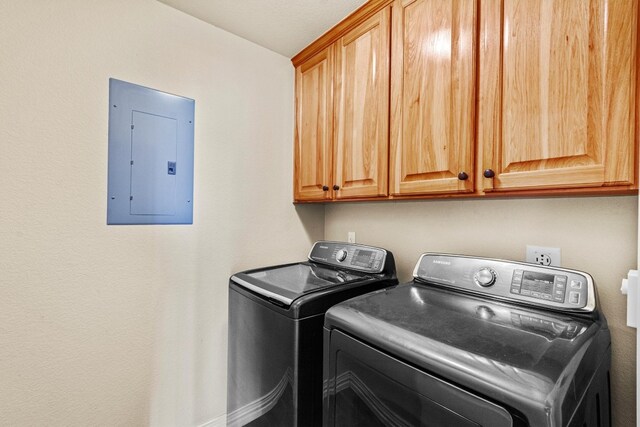 washroom with cabinets and washing machine and clothes dryer