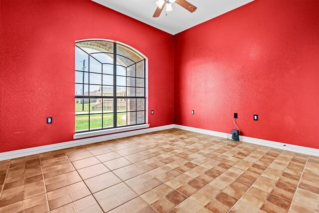 tiled spare room featuring ceiling fan