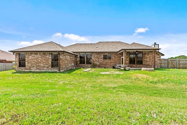 rear view of property featuring a lawn