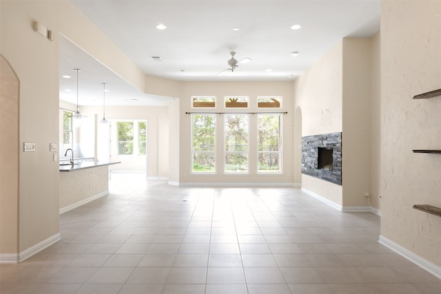 unfurnished living room with ceiling fan and light tile floors