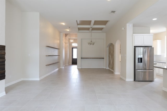 foyer entrance featuring coffered ceiling, a notable chandelier, and light tile flooring