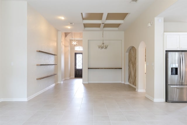 foyer with a chandelier, coffered ceiling, and light tile flooring