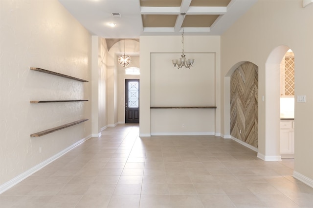 spare room with coffered ceiling, a high ceiling, light tile floors, and a notable chandelier