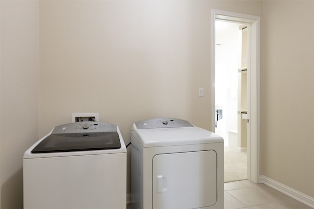 laundry area featuring light tile floors and washer and dryer