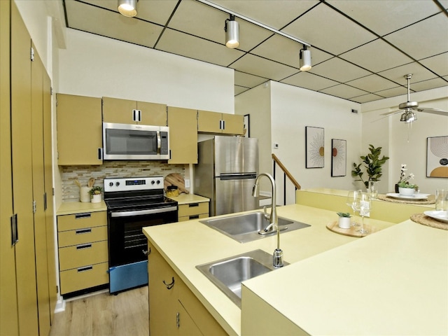 kitchen with stainless steel appliances, backsplash, ceiling fan, track lighting, and sink