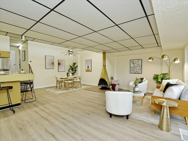 living room featuring ceiling fan, hardwood / wood-style flooring, and a paneled ceiling