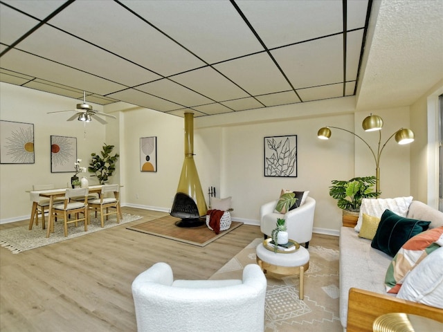 living room with wood-type flooring, ceiling fan, and a drop ceiling