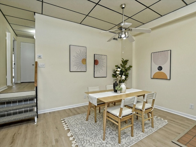 dining area featuring a paneled ceiling, ceiling fan, and hardwood / wood-style flooring