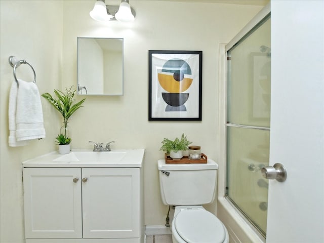 full bathroom featuring bath / shower combo with glass door, vanity, and toilet