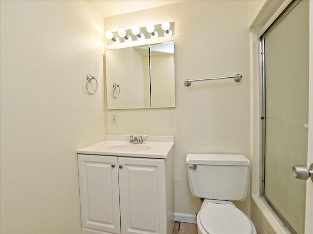 full bathroom featuring vanity with extensive cabinet space, enclosed tub / shower combo, toilet, and tile floors