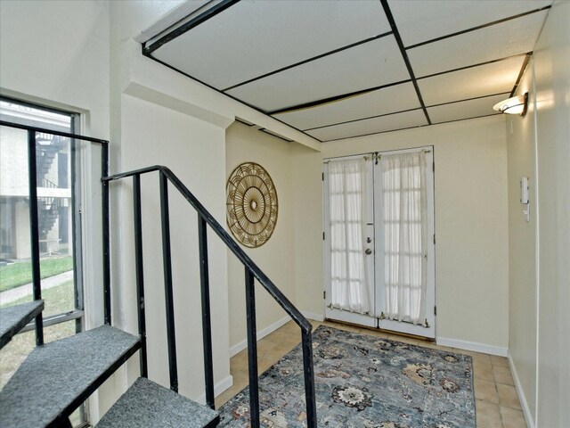 staircase featuring french doors and light tile floors