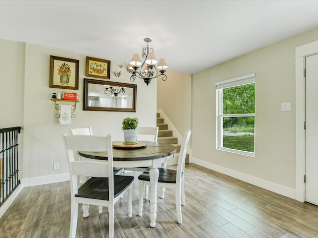 dining area with light hardwood / wood-style flooring and a chandelier