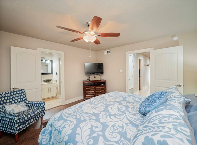 tiled bedroom featuring connected bathroom and ceiling fan