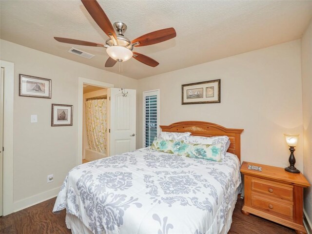 bedroom with a ceiling fan, visible vents, dark wood finished floors, and baseboards