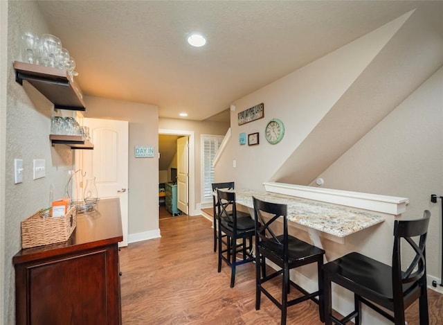 dining room with recessed lighting, wood finished floors, and baseboards