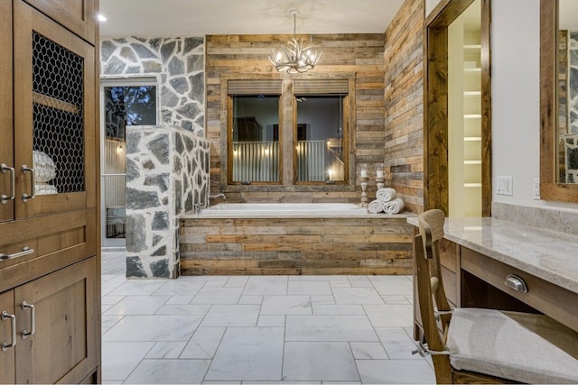 bathroom featuring a notable chandelier, a bath, and vanity