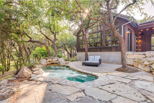 view of pool featuring a jacuzzi and a patio