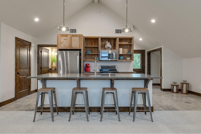 kitchen with stainless steel appliances, pendant lighting, a breakfast bar area, a kitchen island, and lofted ceiling