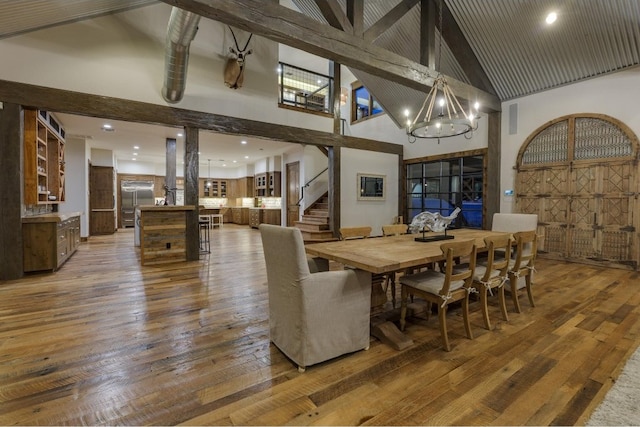 dining room with hardwood / wood-style flooring and high vaulted ceiling