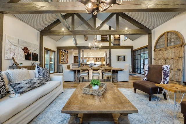 living room featuring a chandelier, beam ceiling, light hardwood / wood-style floors, and high vaulted ceiling