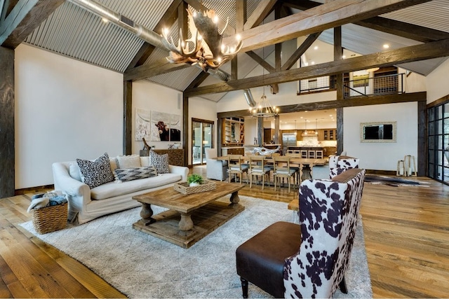 living room with a chandelier, wood-type flooring, high vaulted ceiling, and beamed ceiling