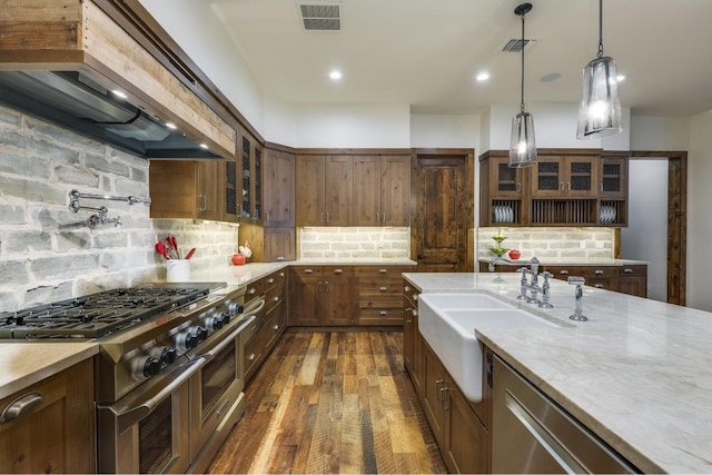 kitchen featuring sink, custom range hood, stainless steel appliances, and tasteful backsplash