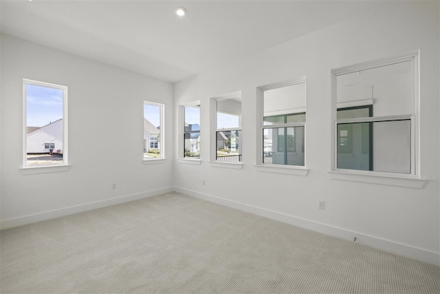 empty room with light colored carpet and a healthy amount of sunlight