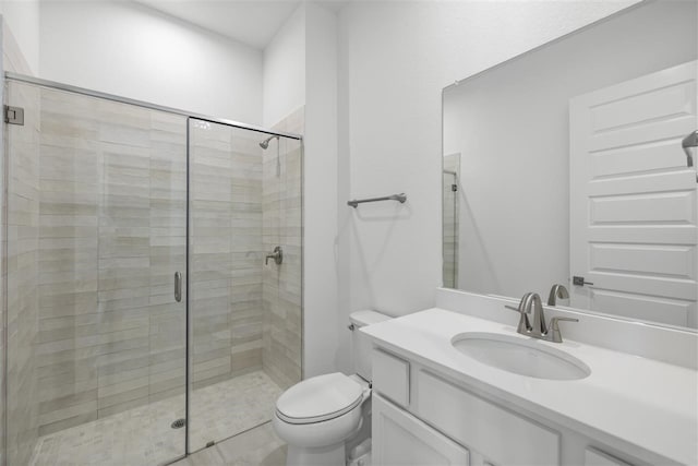 bathroom with vanity, toilet, and a shower with shower door