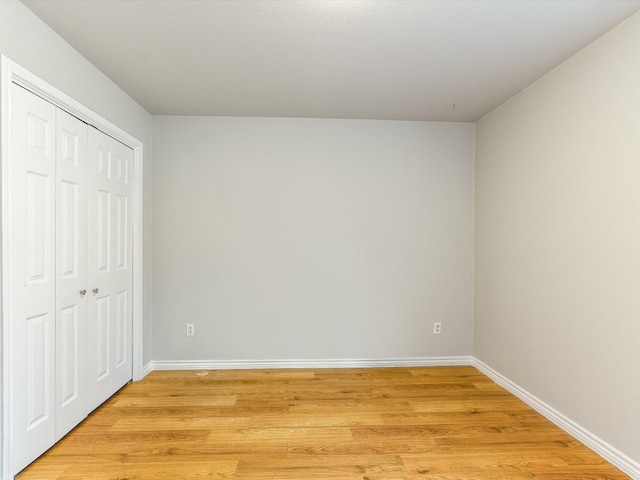 unfurnished bedroom featuring light hardwood / wood-style flooring and a closet