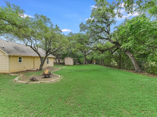 view of yard with an outdoor fire pit and a storage shed