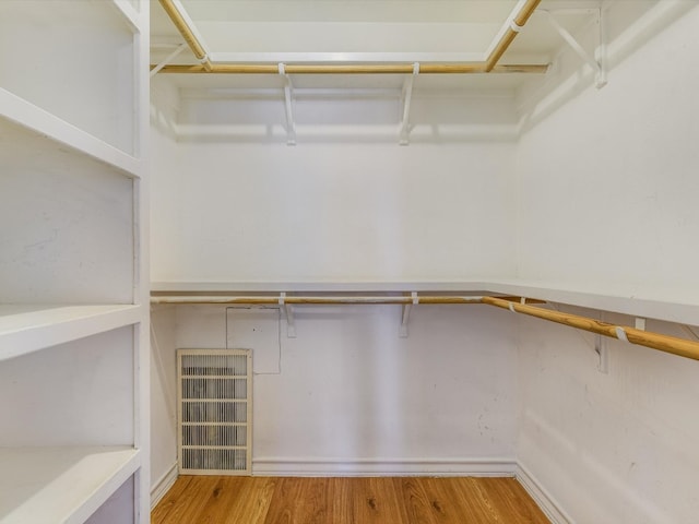 walk in closet with light hardwood / wood-style floors