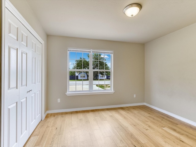 unfurnished bedroom featuring a closet and light hardwood / wood-style floors