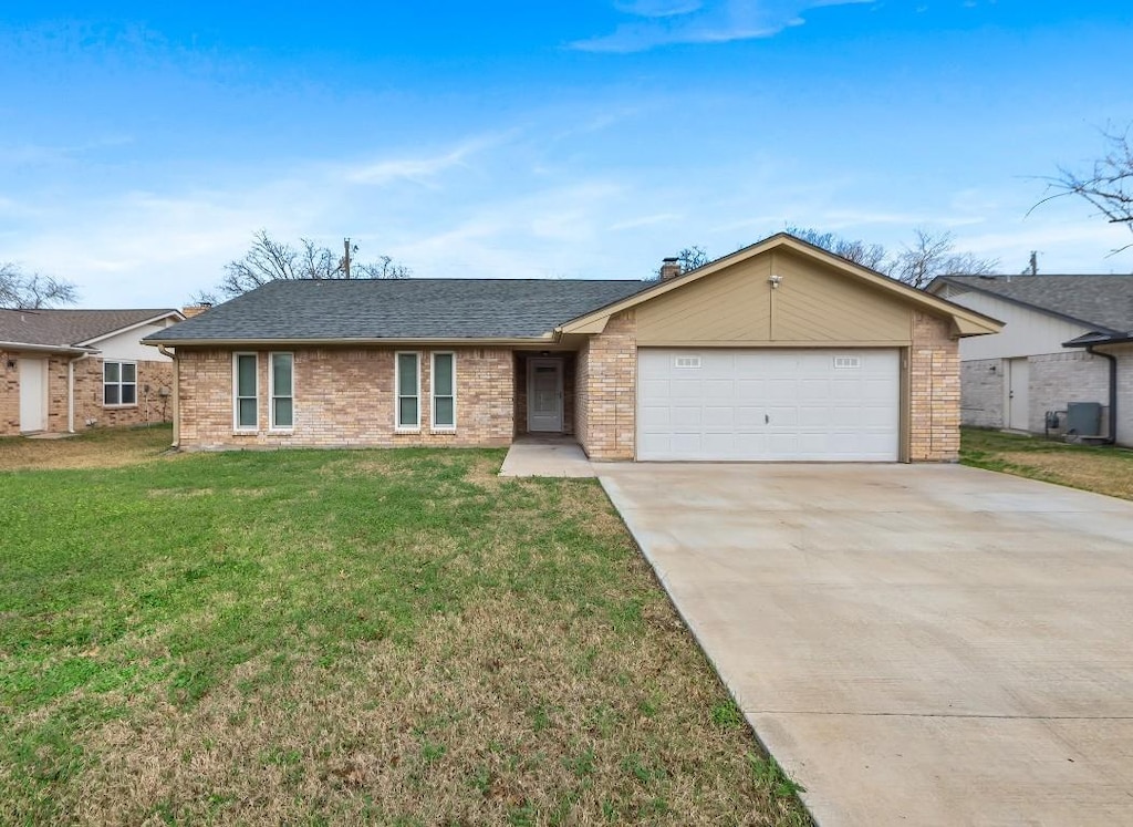 ranch-style home featuring a garage and a front lawn