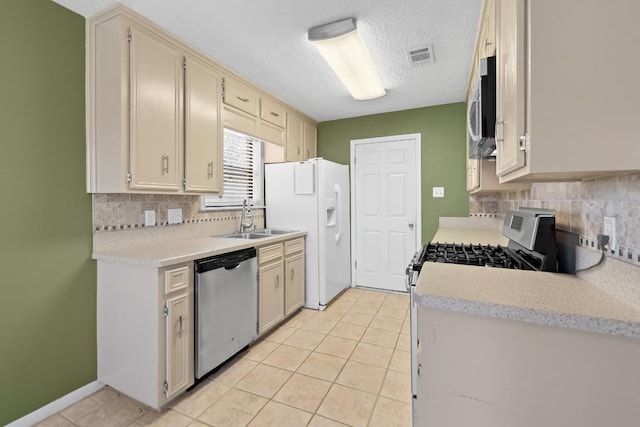 kitchen featuring cream cabinetry, appliances with stainless steel finishes, sink, and light tile patterned floors