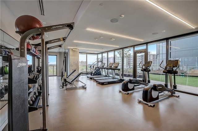 workout area with a view of city and expansive windows