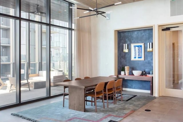 dining space featuring baseboards, a chandelier, and floor to ceiling windows