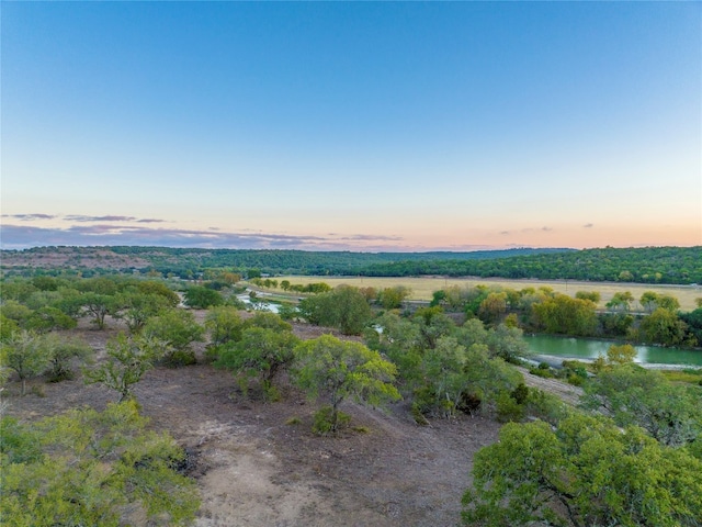 aerial view at dusk featuring a water view