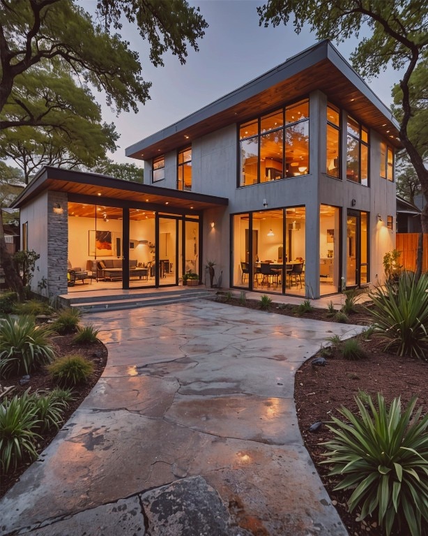 back house at dusk featuring a patio