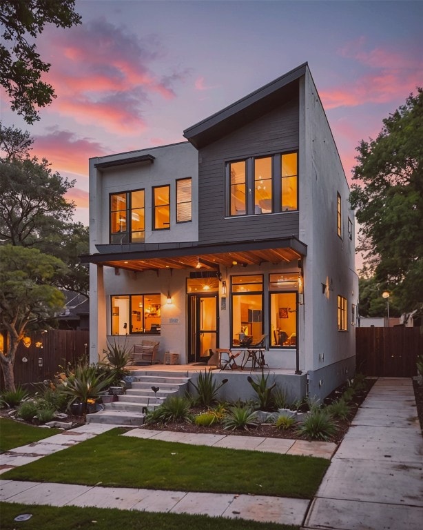 back house at dusk with a porch